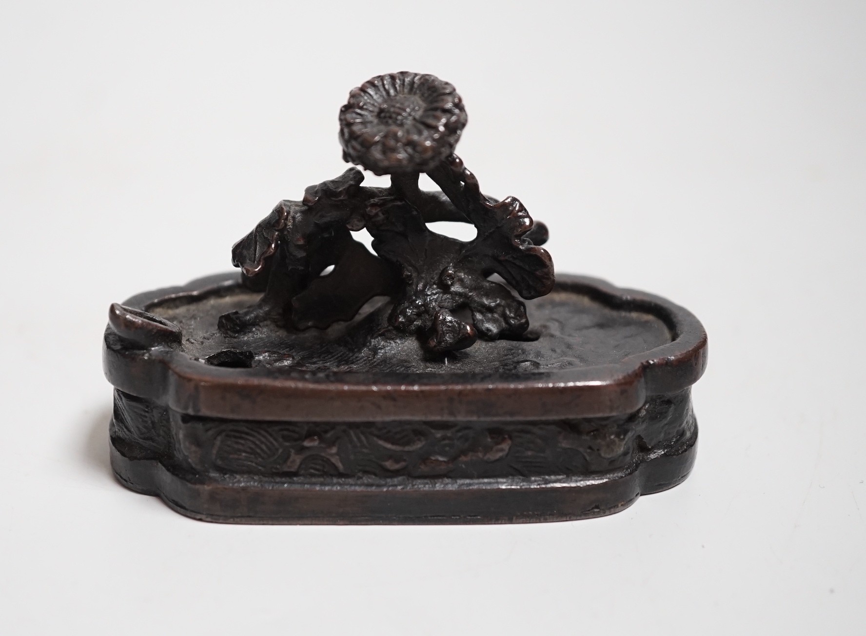 A Chinese bronze water-dropper of a flowering shrub in a jardiniere, 17th/18th century, 8cms wide